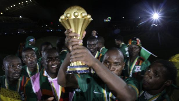 Eine Gruppe von Fußballspielern feiert mit der Trophäe des Afrika-Cups.