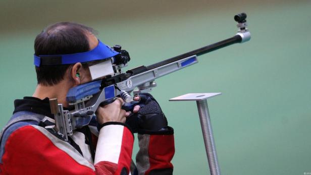 Ein Schütze zielt mit einem Gewehr auf eine Zielscheibe.