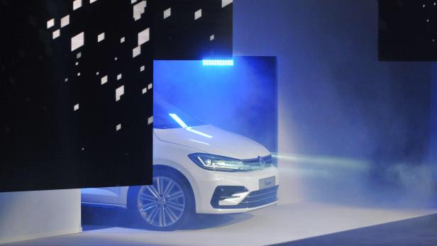 Ein weißer VW Touran steht im Rampenlicht.