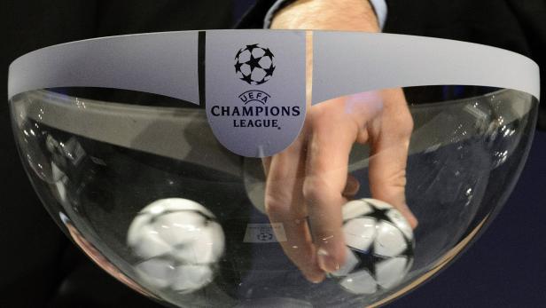 Eine Hand greift in eine Losbox der UEFA Champions League.