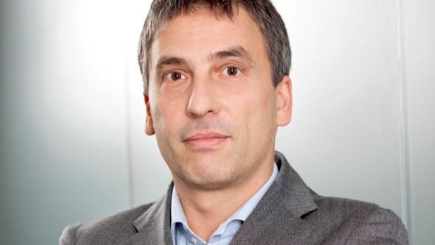 Ein Mann mit grauem Haar und einem grauen Sakko blickt in die Kamera.