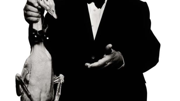 Alfred Hitchcock hält eine tote Gans in der Hand.