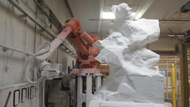 Ein Industrieroboter bearbeitet eine Skulptur aus Styropor.