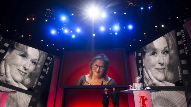 Meryl Streep auf der Berlinale-Bühne mit ihrem Porträt im Hintergrund.