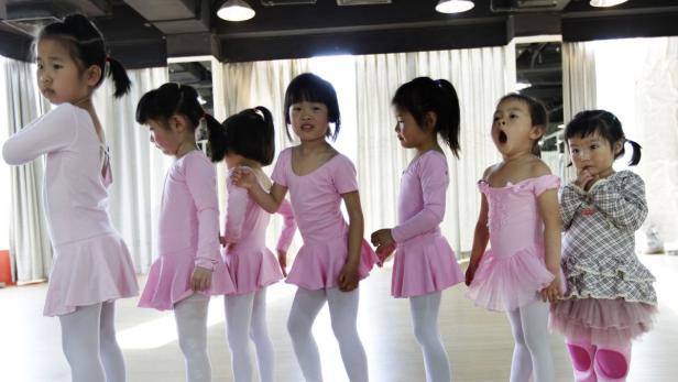 A girl yawns as she stands in line with other students waiting to practise ballet at Feier Angel Dance training centre in Beijing April 23, 2011. About 100 girls, mostly between the age of three and seven, learn ballet at the centre. REUTERS/Jason Lee (CHINA - Tags: SOCIETY)
