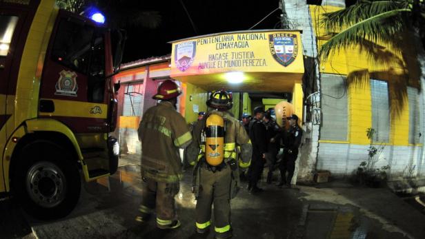 Feuerwehrleute stehen vor der Penitenciaria Nacional Comayagua in Honduras.