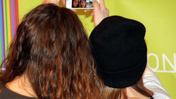 Zwei Frauen machen ein Selfie mit einem Smartphone.