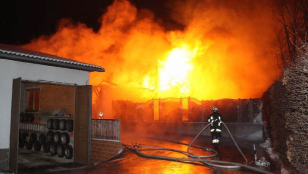 Ein Feuerwehrmann bekämpft einen Brand in der Nacht.