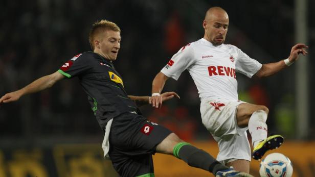 Zwei Fußballspieler kämpfen um den Ball während eines Spiels.