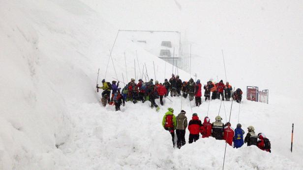 Eine Gruppe von Menschen steht im Schnee vor einem Gebäude.