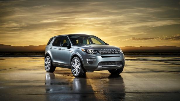 Ein silberner Land Rover Discovery vor einem Sonnenuntergang.