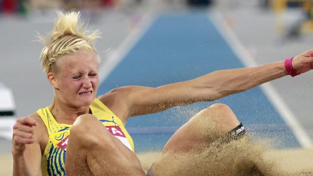 Eine Weitspringerin landet in der Sandgrube.