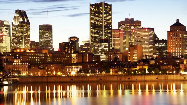 Die Skyline von Montreal spiegelt sich im Wasser bei Nacht.
