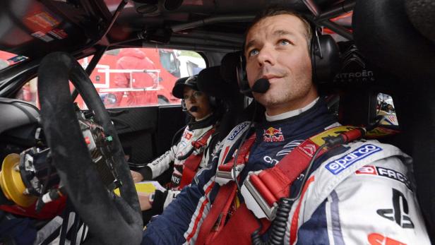 Ein Rallyefahrer und sein Beifahrer sitzen im Cockpit eines Rennwagens.