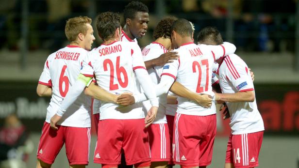 Mehrere Fußballspieler umarmen sich auf dem Spielfeld.