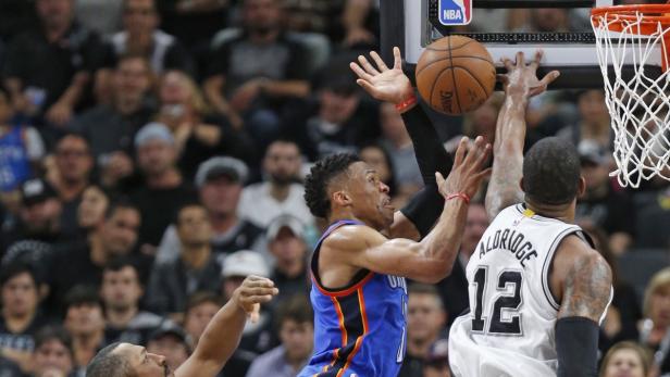 Zwei Basketballspieler kämpfen um den Ball unter dem Korb.
