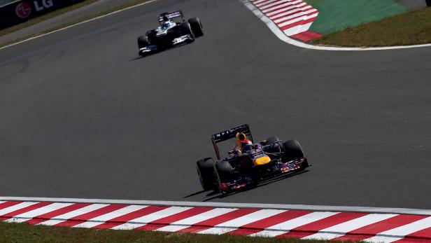 Zwei Formel-1-Autos rasen auf einer Rennstrecke.
