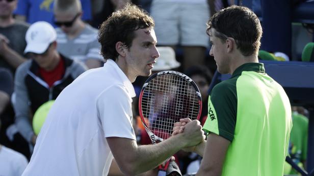 Zwei Tennisspieler schütteln sich nach einem Match die Hände.