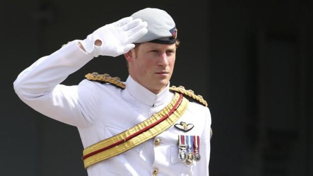 Prinz Harry in Marineuniform salutiert.