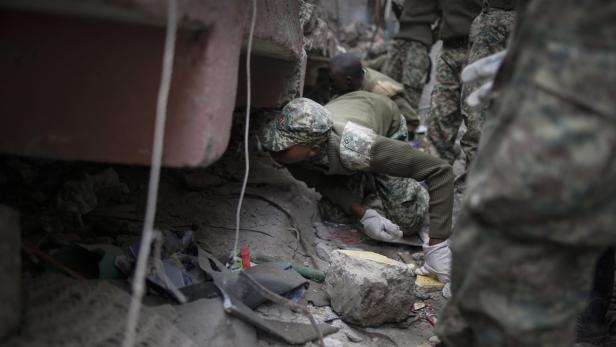 Soldaten suchen in Trümmern nach Überlebenden.
