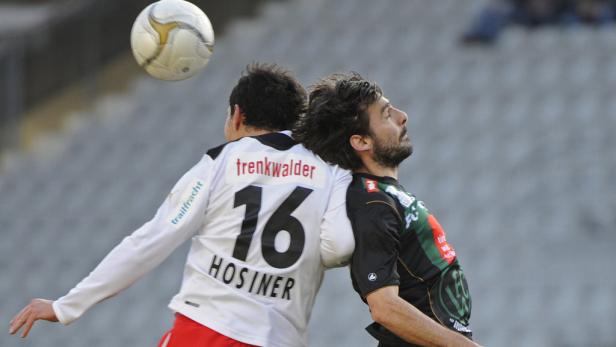 Zwei Fußballspieler kämpfen um einen Ball in der Luft.