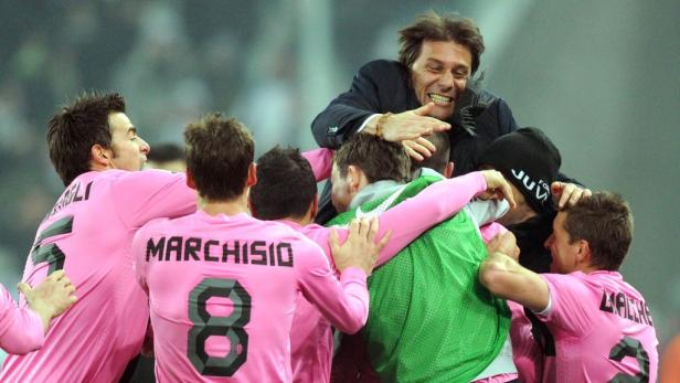 Der Trainer von Juventus Turin wird von seinen Spielern umarmt.
