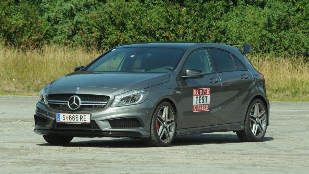 Ein grauer Mercedes-Benz A 45 AMG steht vor einer grünen Hecke.