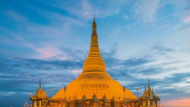 Die goldene Shwedagon-Pagode in Yangon, Myanmar, erstrahlt im Abendlicht.
