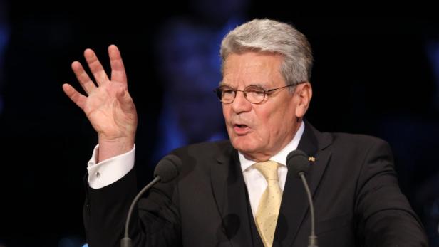 Joachim Gauck gestikuliert bei einer Rede vor Mikrofonen.