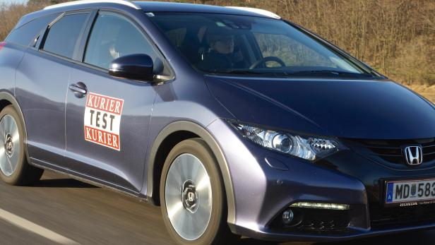 Ein blauer Honda Civic Kombi fährt auf einer Landstraße.