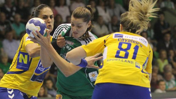 Drei Handballspielerinnen kämpfen um den Ball während eines Spiels.