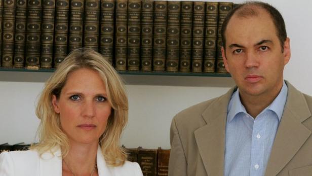 Eine Frau und ein Mann stehen vor einem Bücherregal.