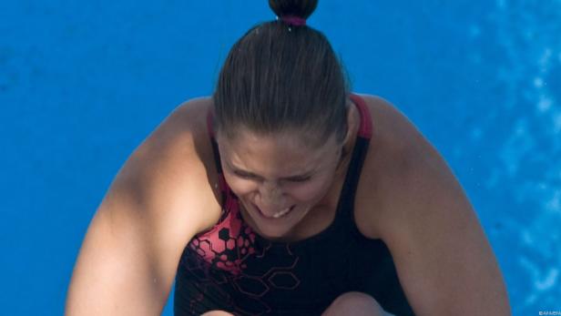 Eine Schwimmerin bereitet sich auf einen Sprung ins blaue Wasser vor.