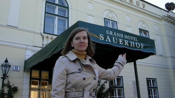 Eine Frau steht vor dem Grand Hotel Sauerhof.