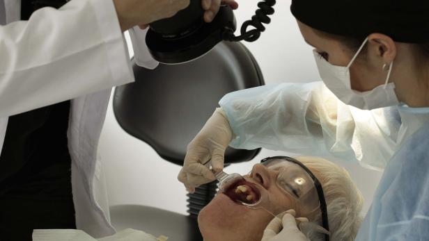 A dentist takes a photo of the mouth of Marlene Trithardt, a Canadian patient, at a dental clinic in Sabanilla, near San Jose November 1, 2012. Around 40,000 medical tourists visited Costa Rica last year, compared to 36,000 in 2010 and 30,000 in 2009. Most of them are American and Canadian, according to the country&#039;s tourism institute, ICT. Of that number, almost 15,000 of them traveled for dental care, said Massimo Manzi, director at Promed, the council for international promotion of medicine in Costa Rica. Picture taken November 1, 2012. To match story COSTARICA-TOURISM/ REUTERS/Juan Carlos Ulate (COSTA RICA - Tags: HEALTH SOCIETY TRAVEL)