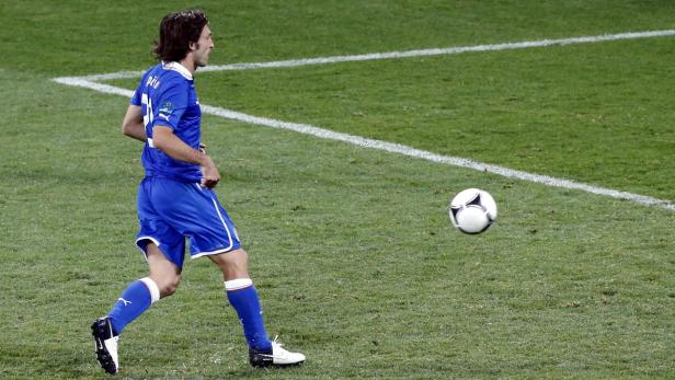 Ein Fußballspieler in blauer Uniform auf einem grünen Rasenplatz.