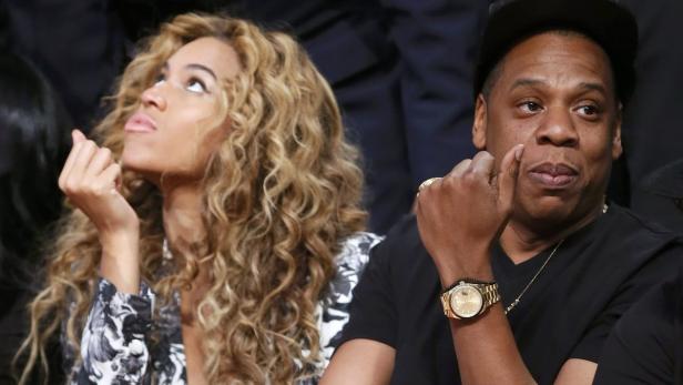 Beyoncé und Jay-Z sitzen nebeneinander und schauen nach oben.