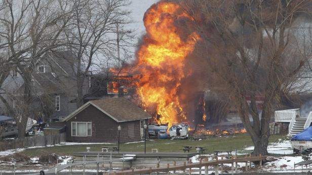 A house burns after a man set fire and then shot and killed a responding police officer and a firefighter while injuring two other firefighters in Webster, New York, December 24, 2012. A gunman shot dead two volunteer firefighters and injured two others when he ambushed them at the scene of an early morning housefire in a suburb of Rochester, New York, authorities said on Monday. REUTERS/Jamie Germano/Democrat and Chronicle/Handout (UNITED STATES - Tags: CRIME LAW DISASTER) NO SALES. NO ARCHIVES. FOR EDITORIAL USE ONLY. NOT FOR SALE FOR MARKETING OR ADVERTISING CAMPAIGNS. THIS IMAGE HAS BEEN SUPPLIED BY A THIRD PARTY. IT IS DISTRIBUTED, EXACTLY AS RECEIVED BY REUTERS, AS A SERVICE TO CLIENTS. MANDATORY CREDIT