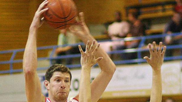 Ein Basketballspieler versucht, einen Ball abzufangen.