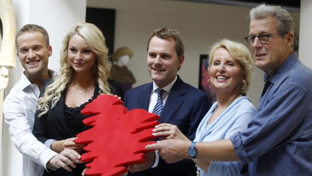 Eine Gruppe von fünf Personen hält gemeinsam ein großes, rotes Herz.