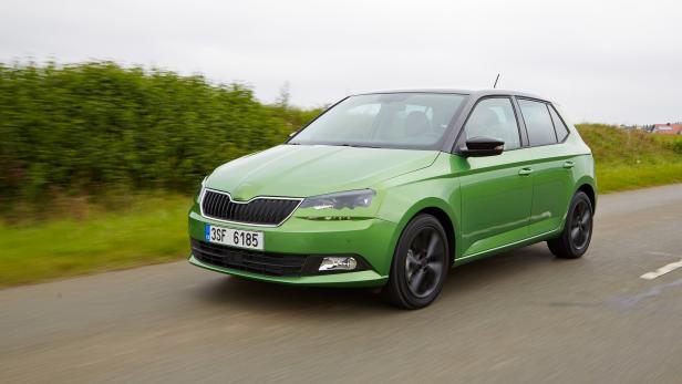 Ein grüner Škoda Fabia fährt auf einer Landstraße.