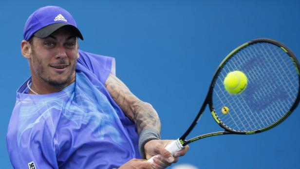 Ein Tennisspieler schlägt einen gelben Tennisball mit seinem Schläger.