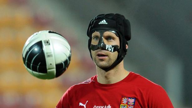 Ein tschechischer Fußballspieler mit Kopfschutz und Gesichtsmaske vor einem Fußball.