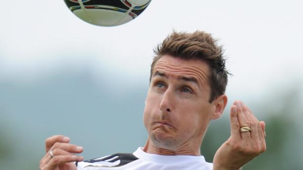 Ein Mann jongliert einen Fußball mit dem Kopf.
