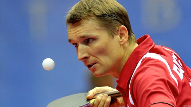 Ein Tischtennisspieler beim Aufschlag mit Blick auf den Ball.