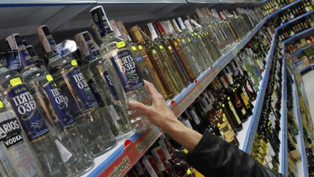 A customer takes a bottle of vodka from a shelf at a Russian supermarket in Benidorm, November 26, 2012. Spain is considering offering rich investors from countries such as Russia and China the right to settle in return for them buying up property worth 160,000 euros ($200,000) or more in the stagnant housing sector, the country&#039;s commerce secretary Jaime Garcia-Legaz said November 19. REUTERS/Heino Kalis (SPAIN - Tags: POLITICS BUSINESS REAL ESTATE)