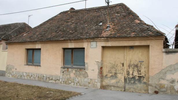 Ein älteres, ebenerdiges Haus mit beschädigtem Putz und einem Ziegeldach.