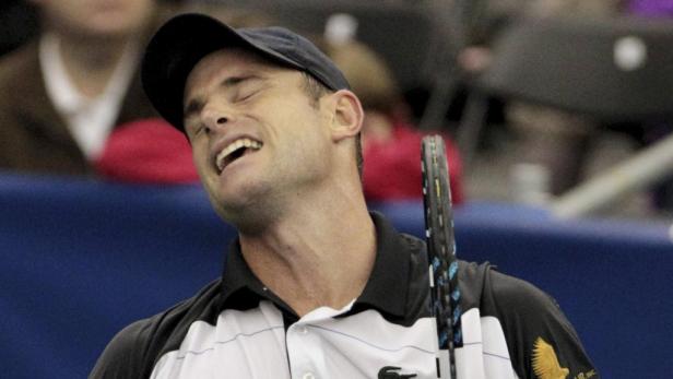 Ein Tennisspieler mit Kappe und Tennisschläger lacht.