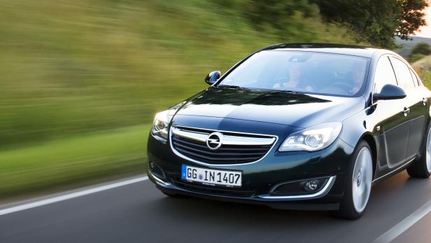 Ein dunkelgrüner Opel Insignia fährt auf einer kurvenreichen Landstraße.