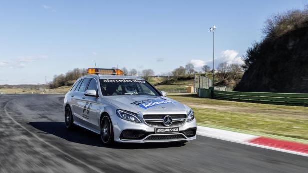 Ein silberner Mercedes-Benz AMG fährt auf einer Rennstrecke.